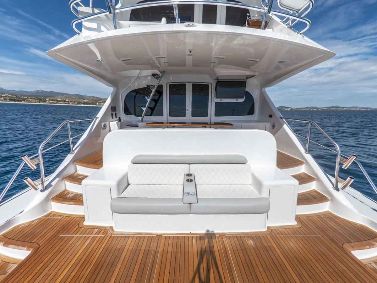 The aft deck features a spacious seating area with elegant wood flooring and a stunning view of the sea. aboard MARLIN MAGIC Yacht for Sale