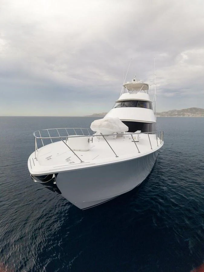 A sleek yacht with a modern design is cruising on calm waters under a cloudy sky. aboard MARLIN MAGIC Yacht for Sale