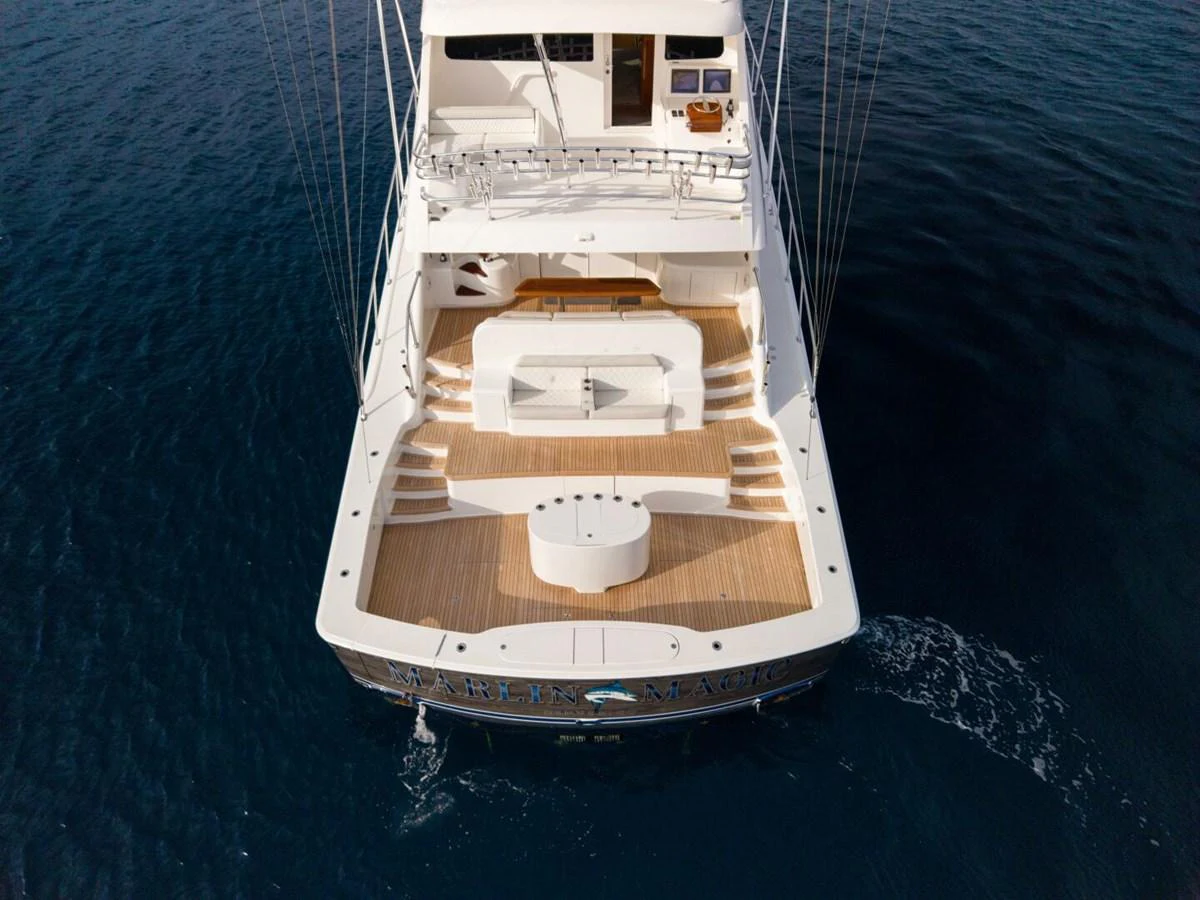 The yacht's aft deck features a spacious and elegant layout with ample seating and a central table, perfect for outdoor relaxation and dining. aboard MARLIN MAGIC Yacht for Sale