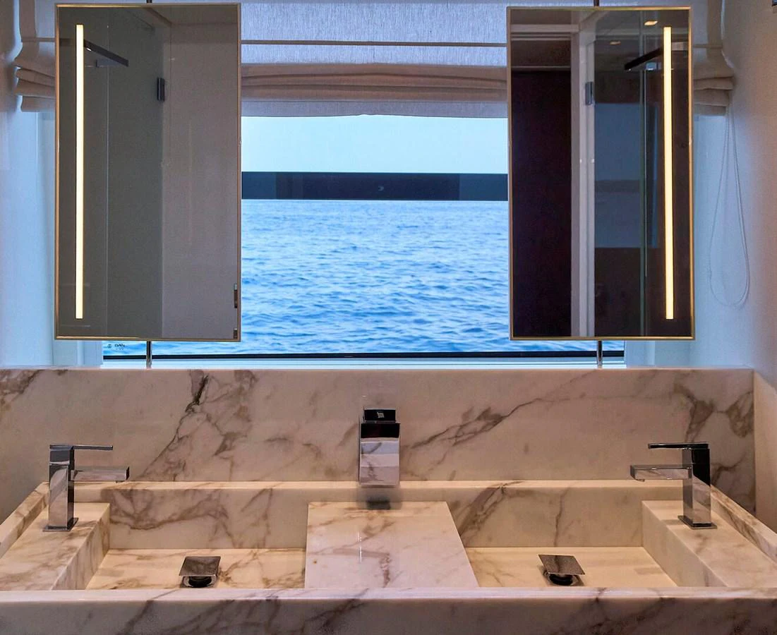 A luxurious bathroom with a marble double sink and a view of the ocean. aboard SANLORENZO SL102 ASYMMETRIC Yacht for Sale