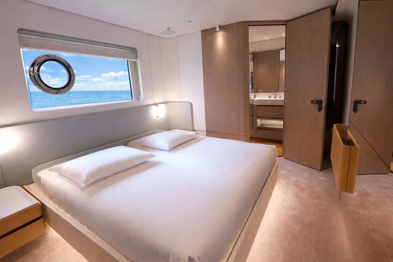 The stateroom features a spacious bed with a view of the sea through a porthole window. aboard SEA STAR Yacht for Sale