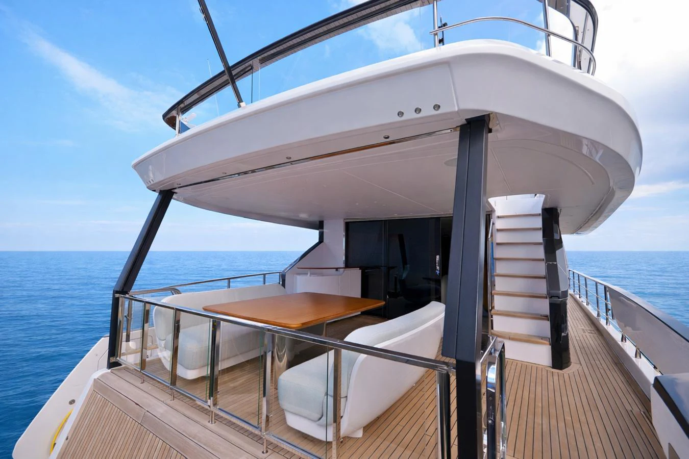 The yacht's aft deck features a spacious seating area with a dining table, perfect for alfresco dining with a view of the open sea. aboard SEA STAR Yacht for Sale