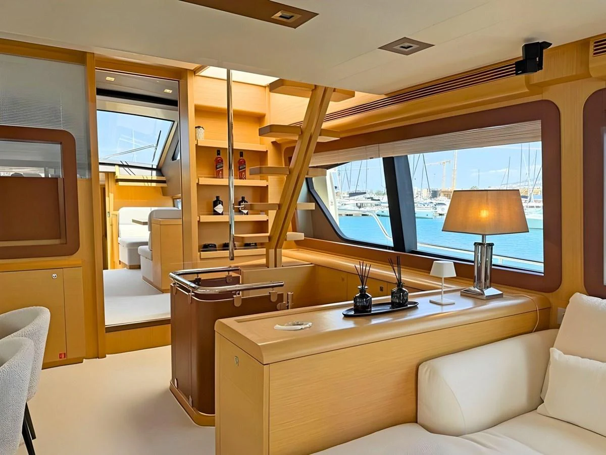 The salon features elegant wood finishes and large windows offering a view of the marina. aboard M/Y ILAV Yacht for Sale