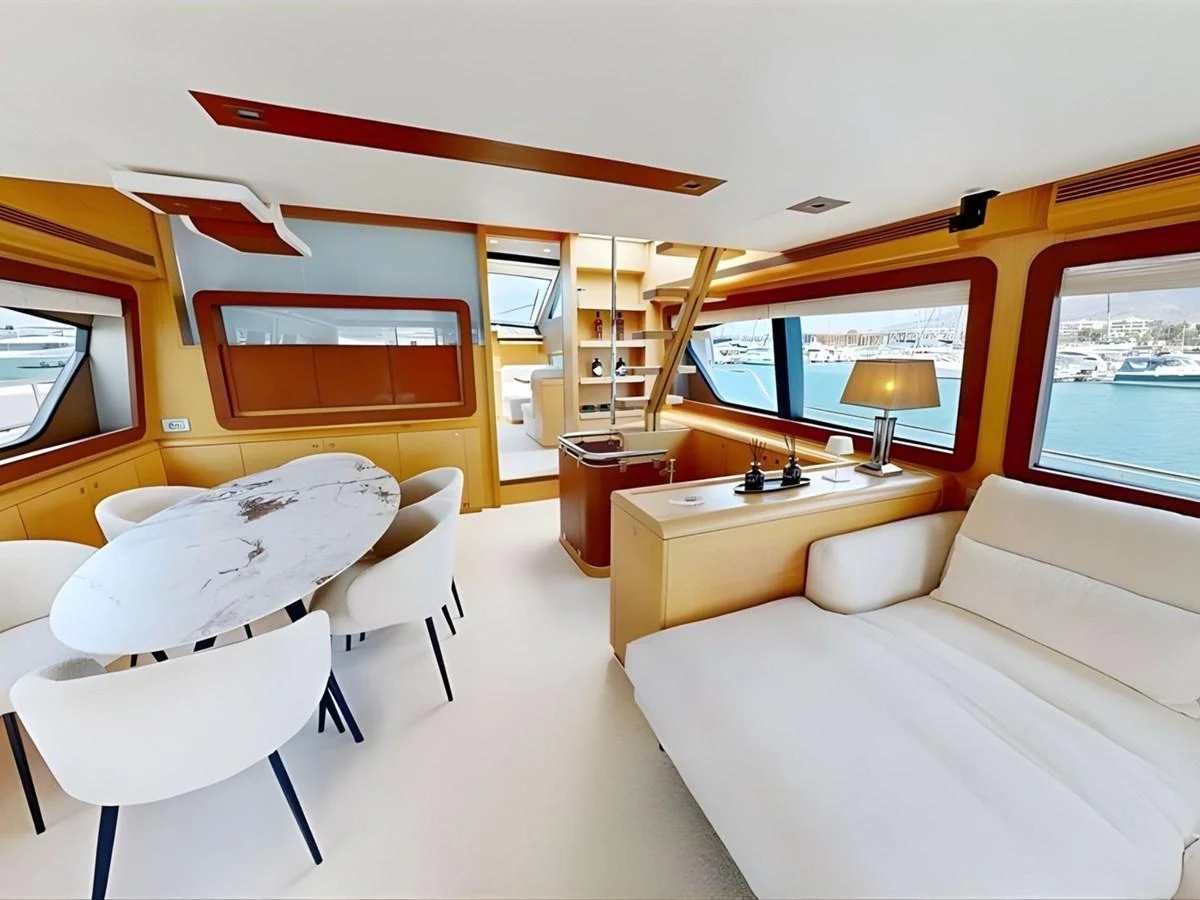 The salon features a modern design with large windows offering stunning marina views. aboard M/Y ILAV Yacht for Sale