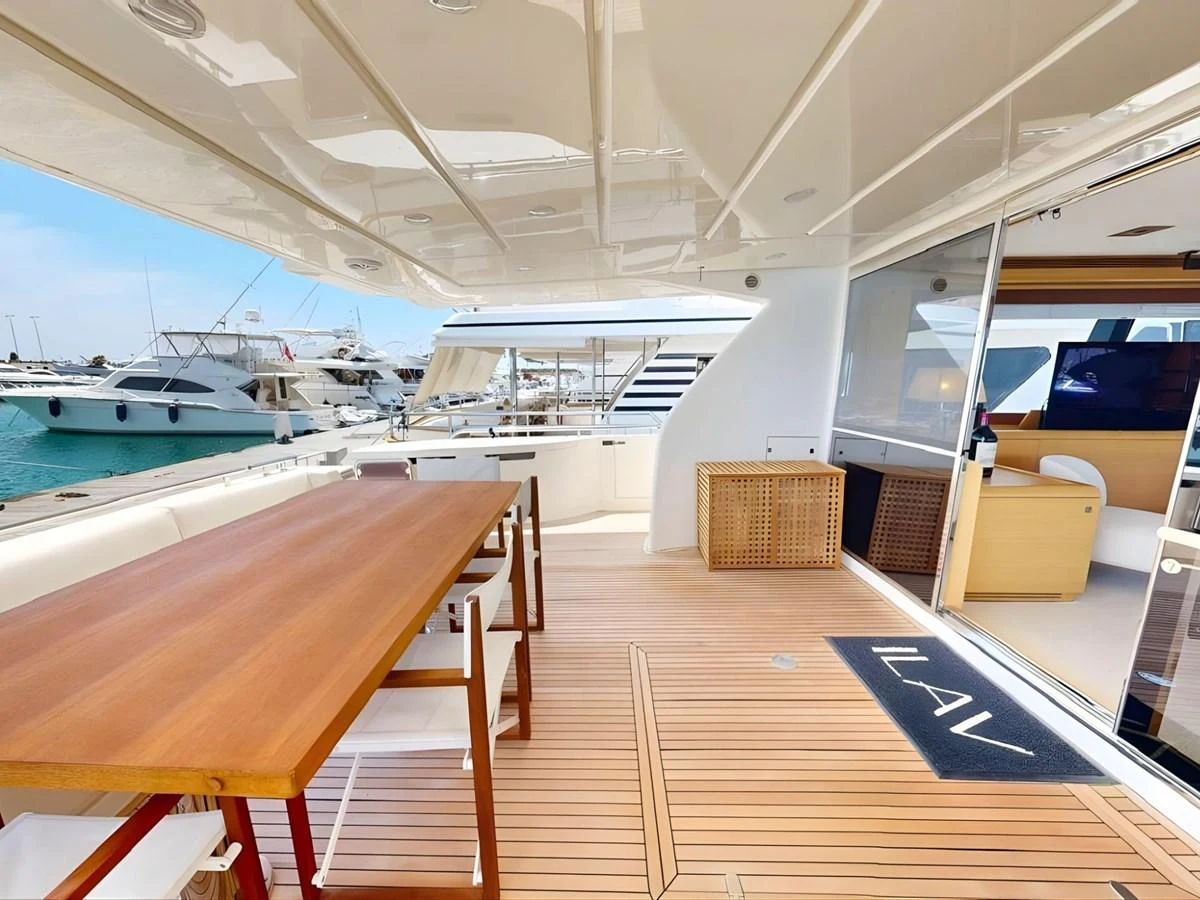 The aft deck features a spacious dining area with a wooden table and comfortable seating, perfect for alfresco meals. aboard M/Y ILAV Yacht for Sale