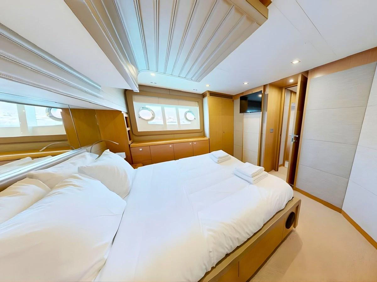 A luxurious stateroom featuring a large bed, modern decor, and ample natural light. aboard M/Y ILAV Yacht for Sale