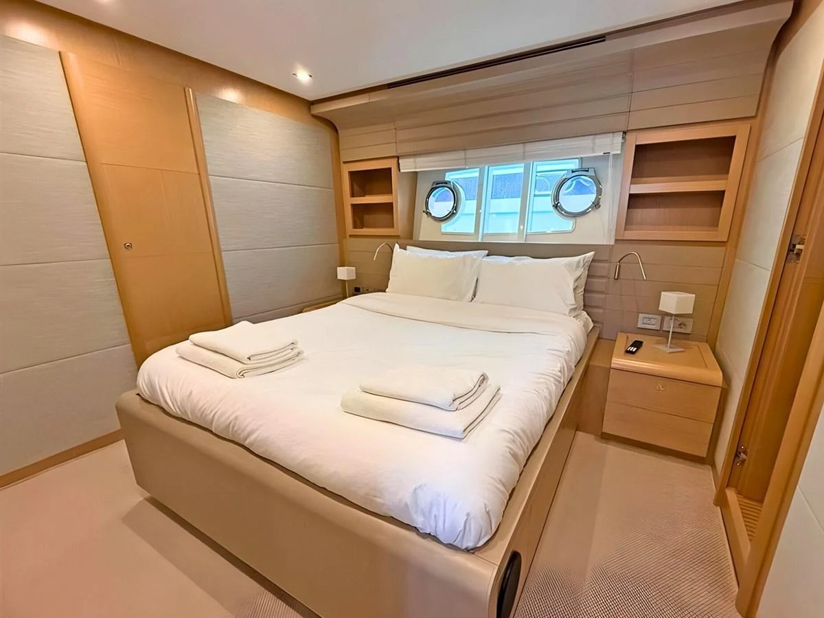 The guest stateroom features a comfortable bed with neatly arranged linens and ample storage space. aboard M/Y ILAV Yacht for Sale