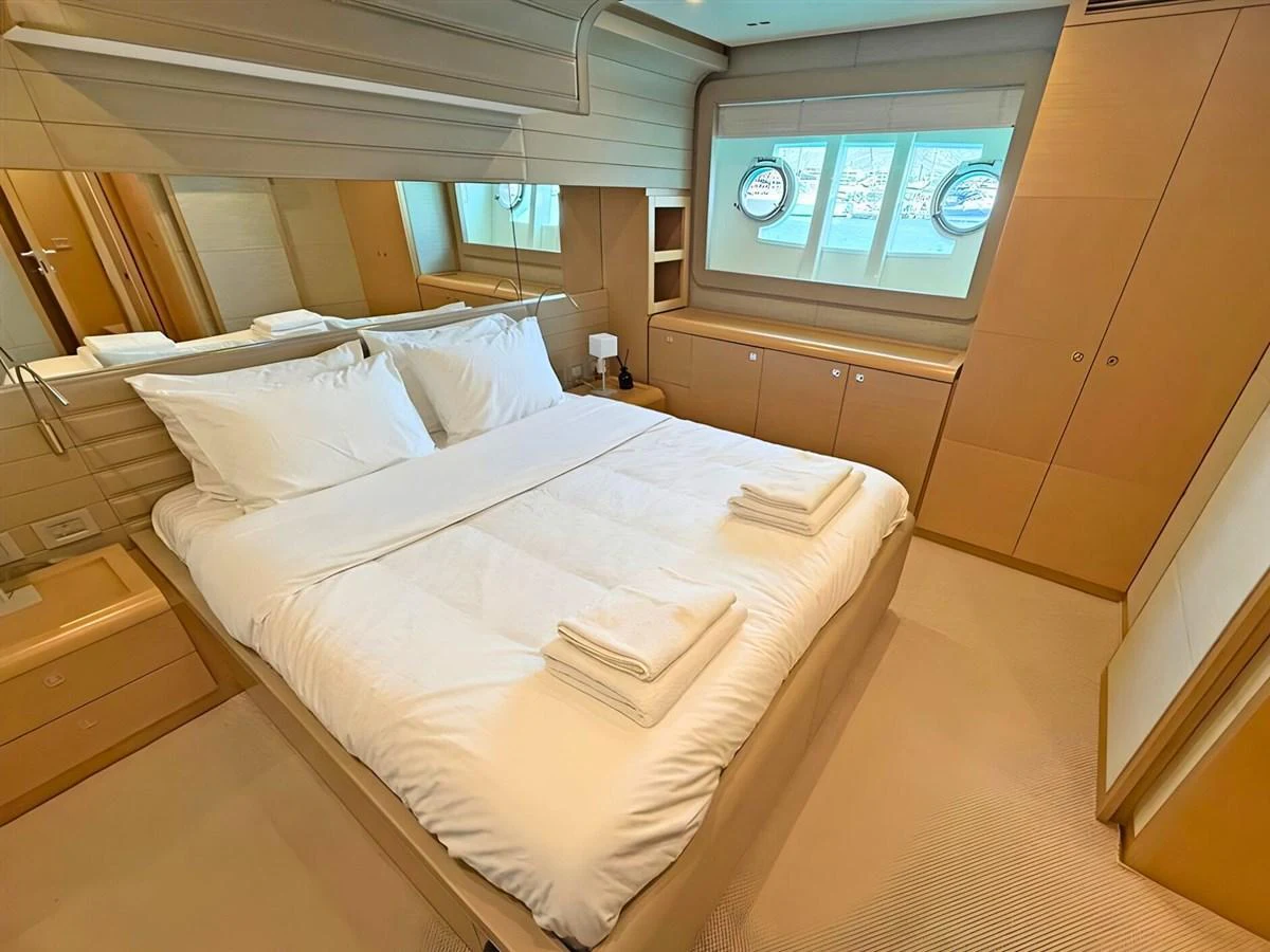 A cozy stateroom with a double bed, ample storage, and natural light from porthole windows. aboard M/Y ILAV Yacht for Sale