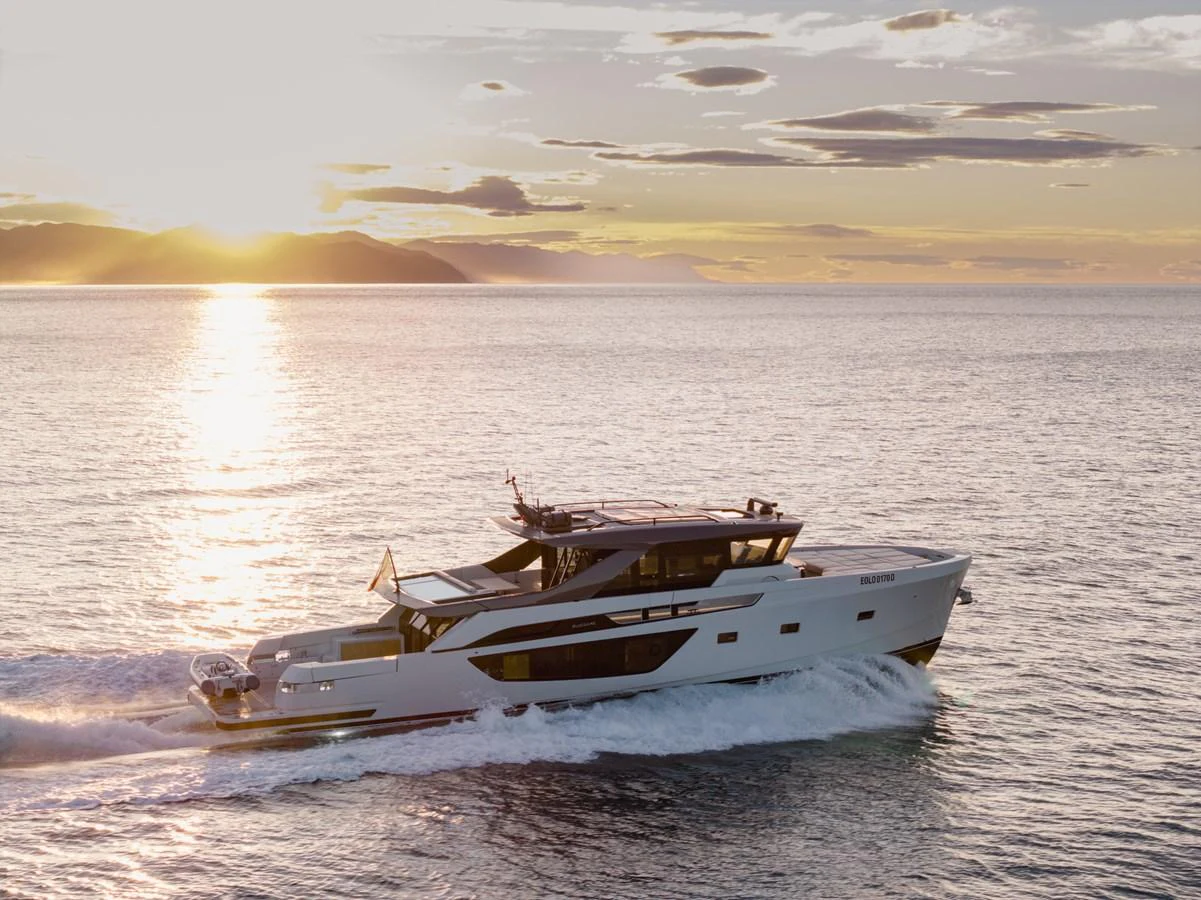 A sleek yacht cruises through calm waters at sunset, showcasing its modern design and elegance. aboard EOLINO Yacht for Sale