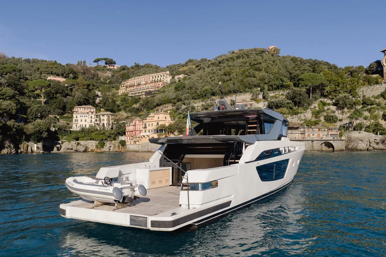 A sleek yacht with a spacious aft deck cruising in a picturesque coastal area. aboard EOLINO Yacht for Sale