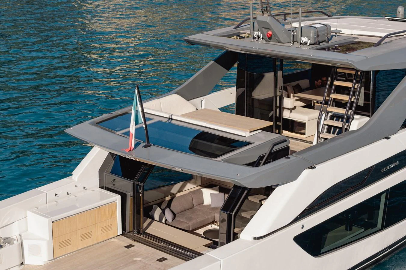 The yacht's aft deck showcases a luxurious lounging area with elegant design and stunning water views. aboard EOLINO Yacht for Sale