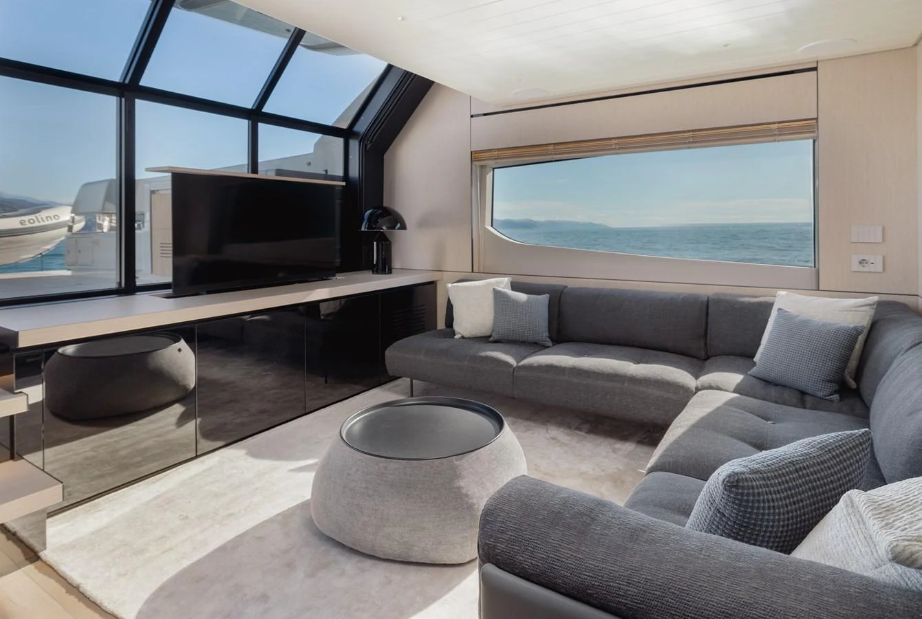 The salon features a spacious and modern seating area with panoramic windows offering stunning ocean views. aboard EOLINO Yacht for Sale