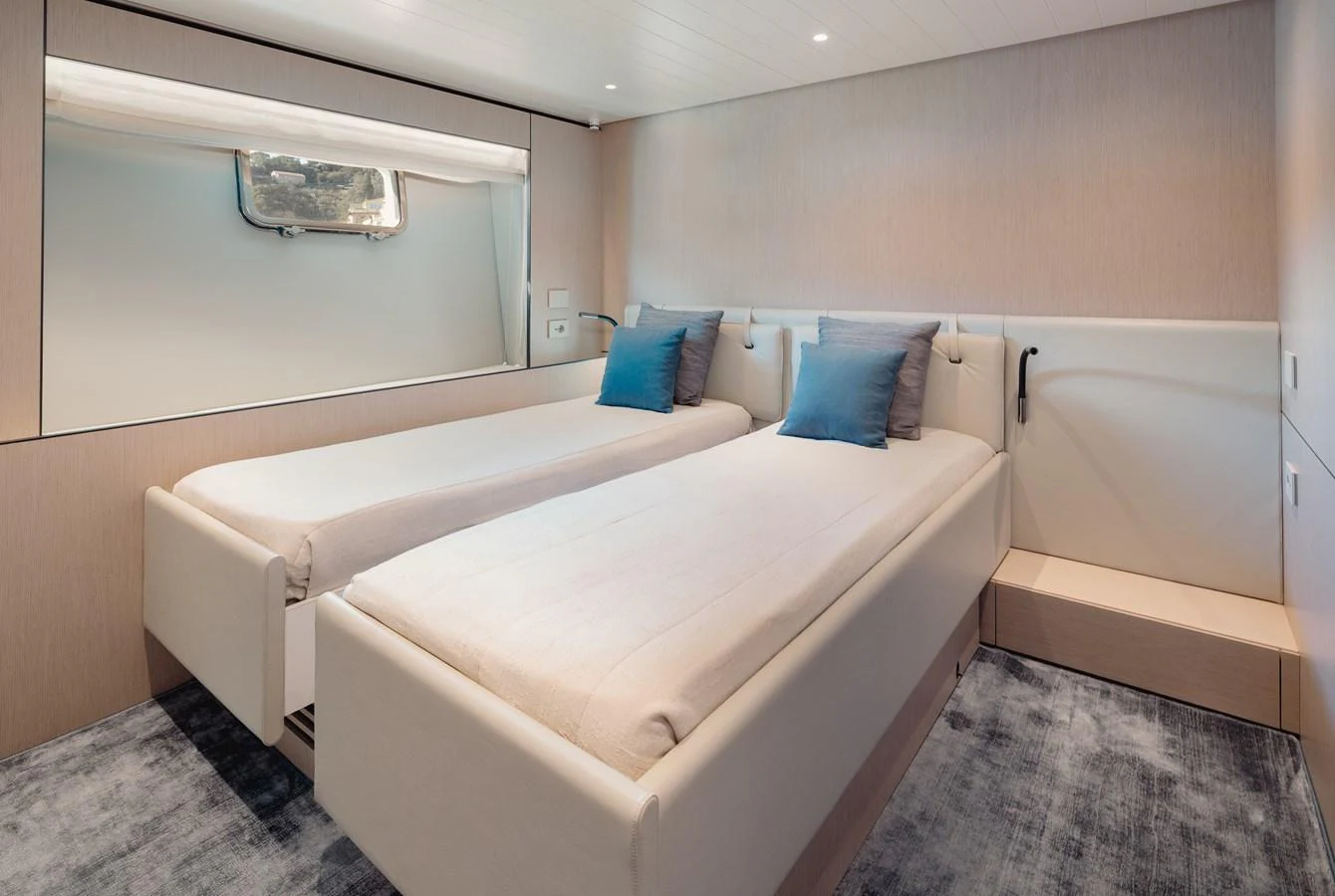 The twin stateroom features two single beds with plush bedding and a serene atmosphere. aboard EOLINO Yacht for Sale