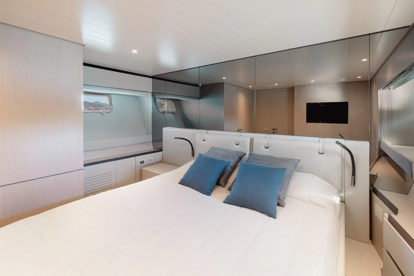 The stateroom features a luxurious bed with plush pillows and modern lighting. aboard EOLINO Yacht for Sale