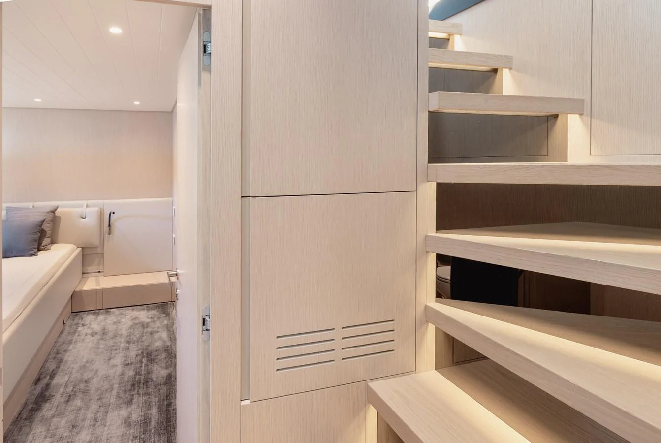 The image showcases a modern, well-lit interior staircase leading to a cozy stateroom. aboard EOLINO Yacht for Sale
