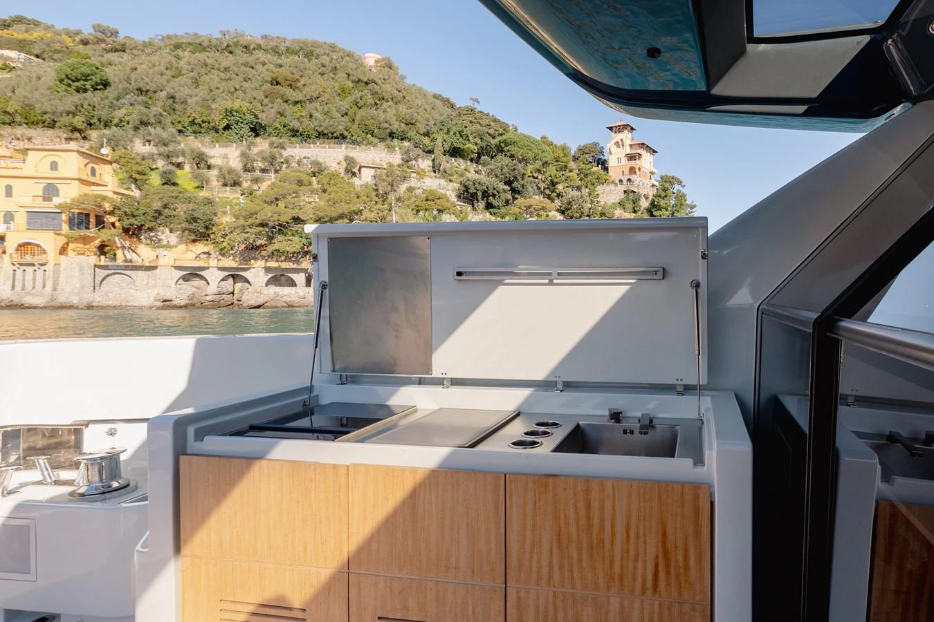 The yacht features a well-equipped outdoor galley with a scenic backdrop. aboard EOLINO Yacht for Sale