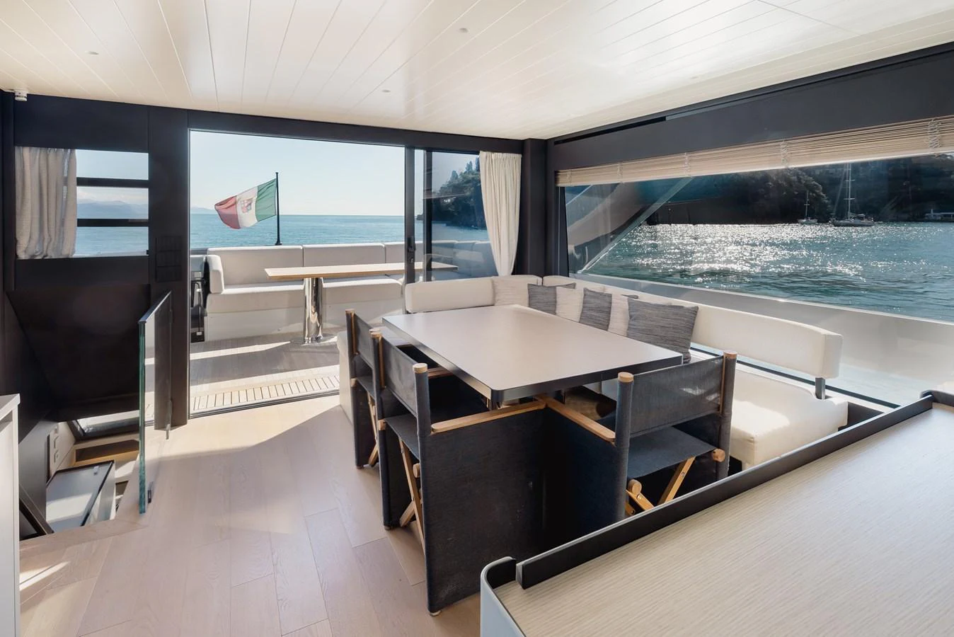 The salon offers a spacious and bright area with large windows and modern furnishings, seamlessly connecting to the aft deck. aboard EOLINO Yacht for Sale