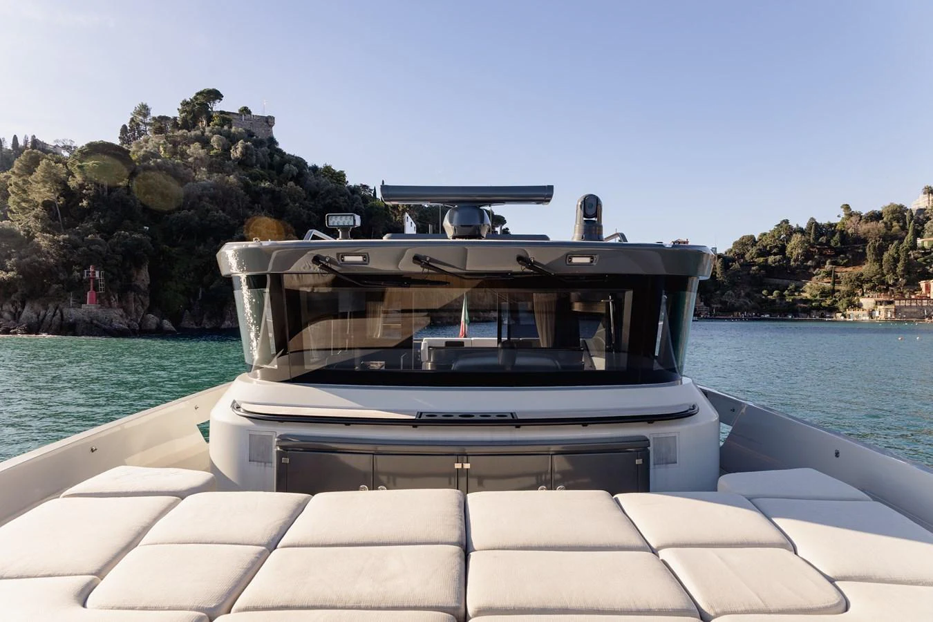 The yacht features a spacious sunpad area with a scenic backdrop of lush greenery and calm waters. aboard EOLINO Yacht for Sale