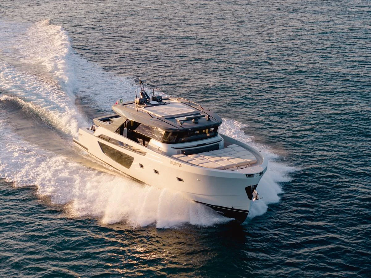 A sleek, modern yacht cruises swiftly through the open water, creating a dynamic wake behind it. aboard EOLINO Yacht for Sale