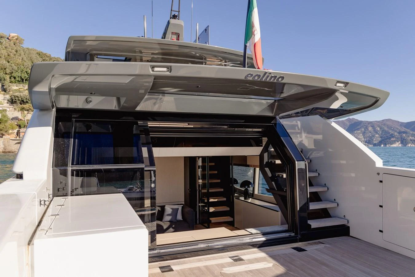 The aft deck of this yacht features a sleek design with an inviting entrance to the interior. aboard EOLINO Yacht for Sale
