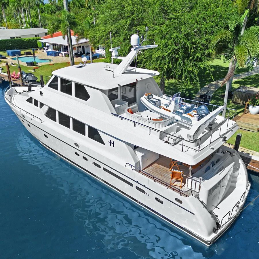 A luxurious yacht is docked in a serene marina, showcasing its sleek design and spacious decks. aboard MILES AWEIGH Yacht for Sale