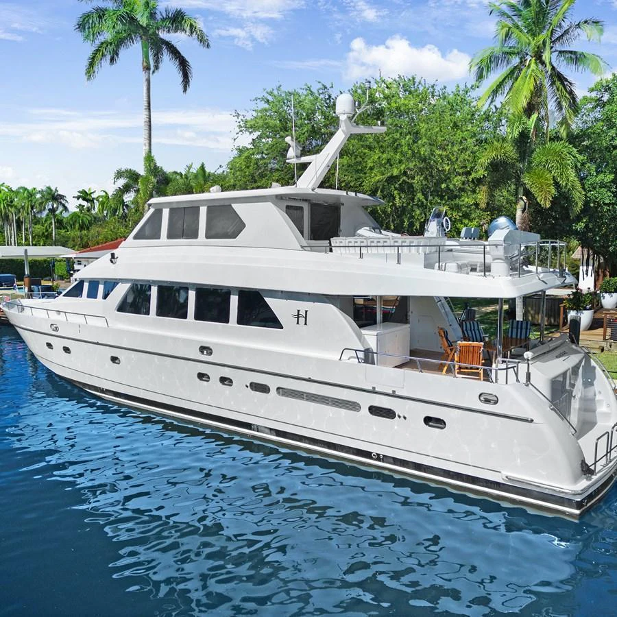 A sleek and modern yacht is docked in a serene tropical setting, showcasing its elegant design and spacious decks. aboard MILES AWEIGH Yacht for Sale