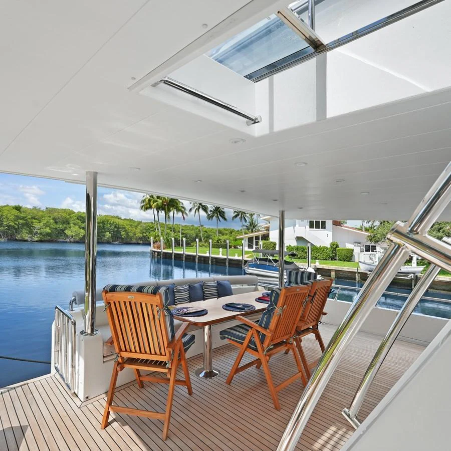 The aft deck features a comfortable dining area with a scenic view of the water. aboard MILES AWEIGH Yacht for Sale