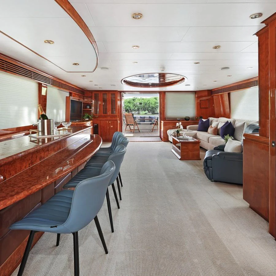 The yacht's salon features luxurious seating, a bar area, and large windows for natural light. aboard MILES AWEIGH Yacht for Sale