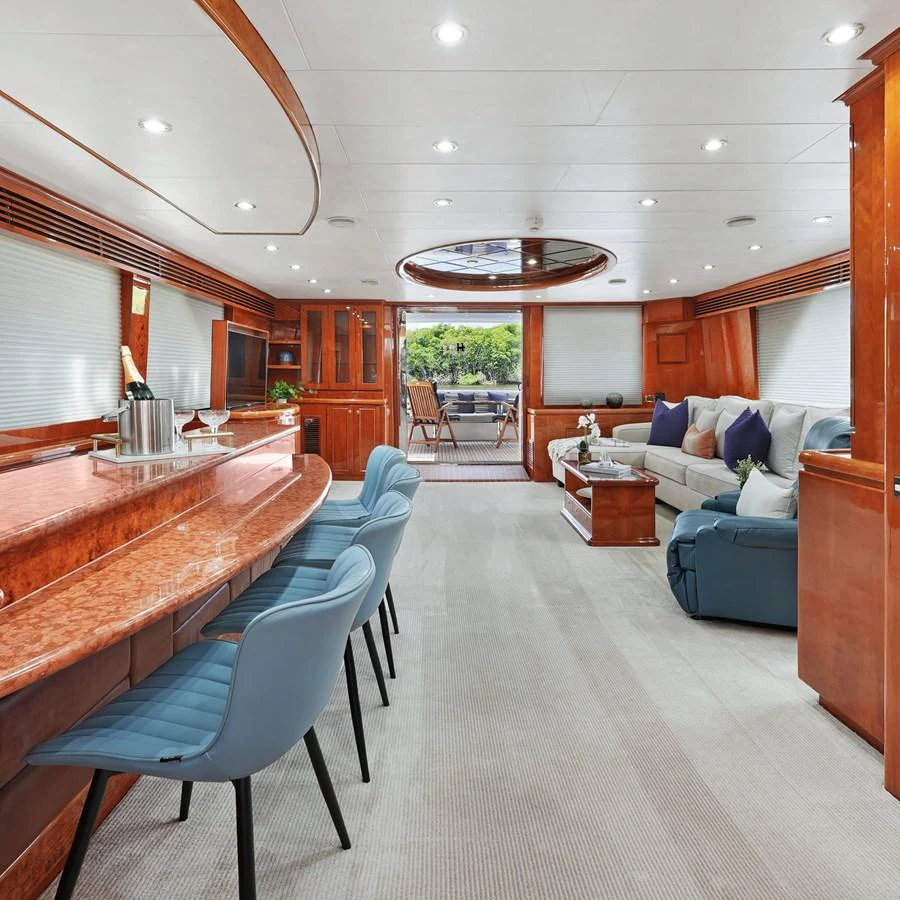 The yacht's salon features a spacious and elegant seating area with a bar and large windows for natural light. aboard MILES AWEIGH Yacht for Sale