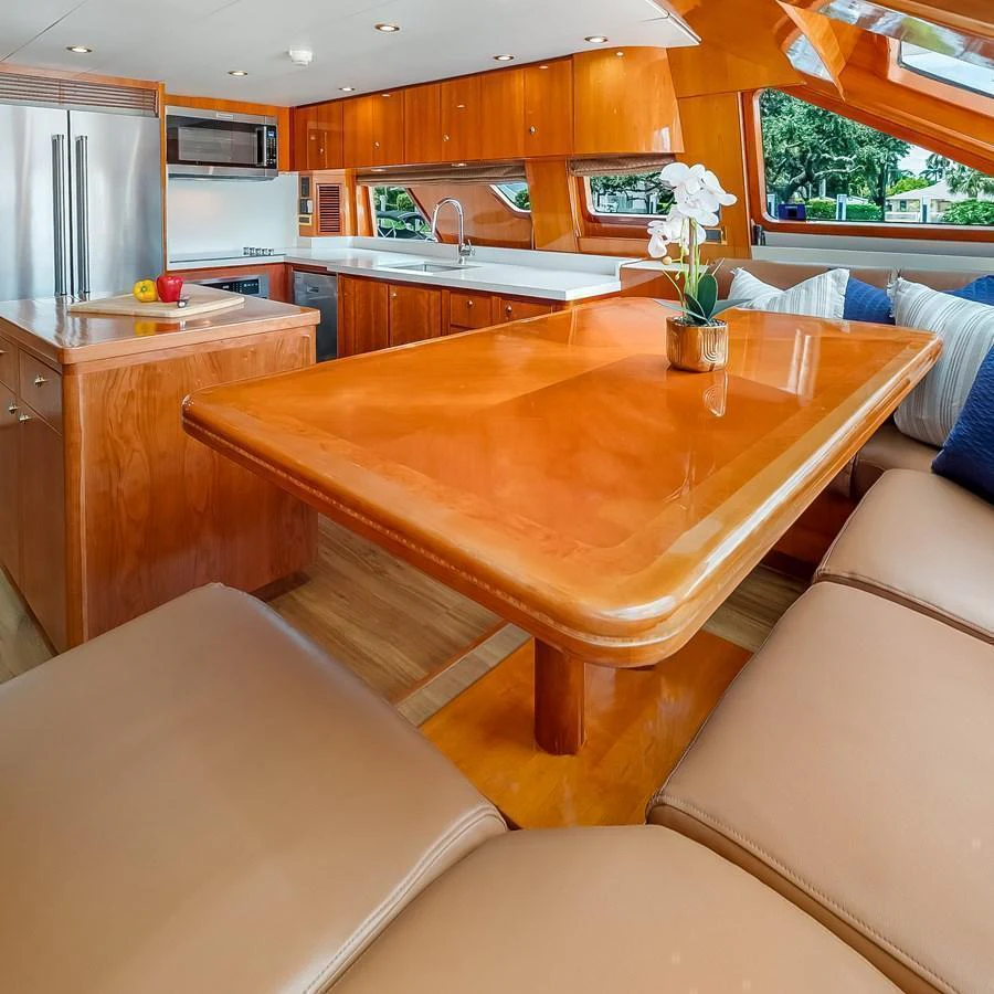The galley features a spacious dining area with a polished wooden table and comfortable seating. aboard MILES AWEIGH Yacht for Sale