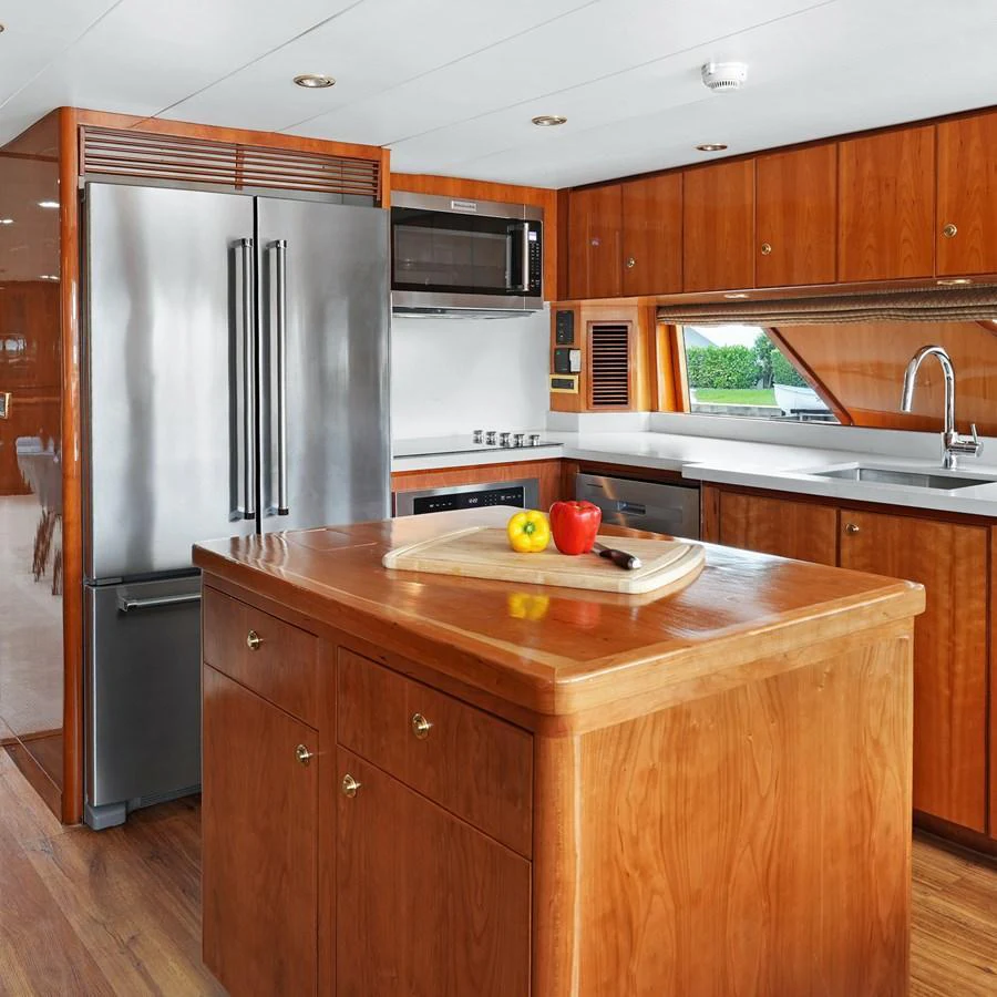 The yacht's galley features modern appliances and elegant wooden cabinetry, creating a warm and inviting space for culinary endeavors. aboard MILES AWEIGH Yacht for Sale