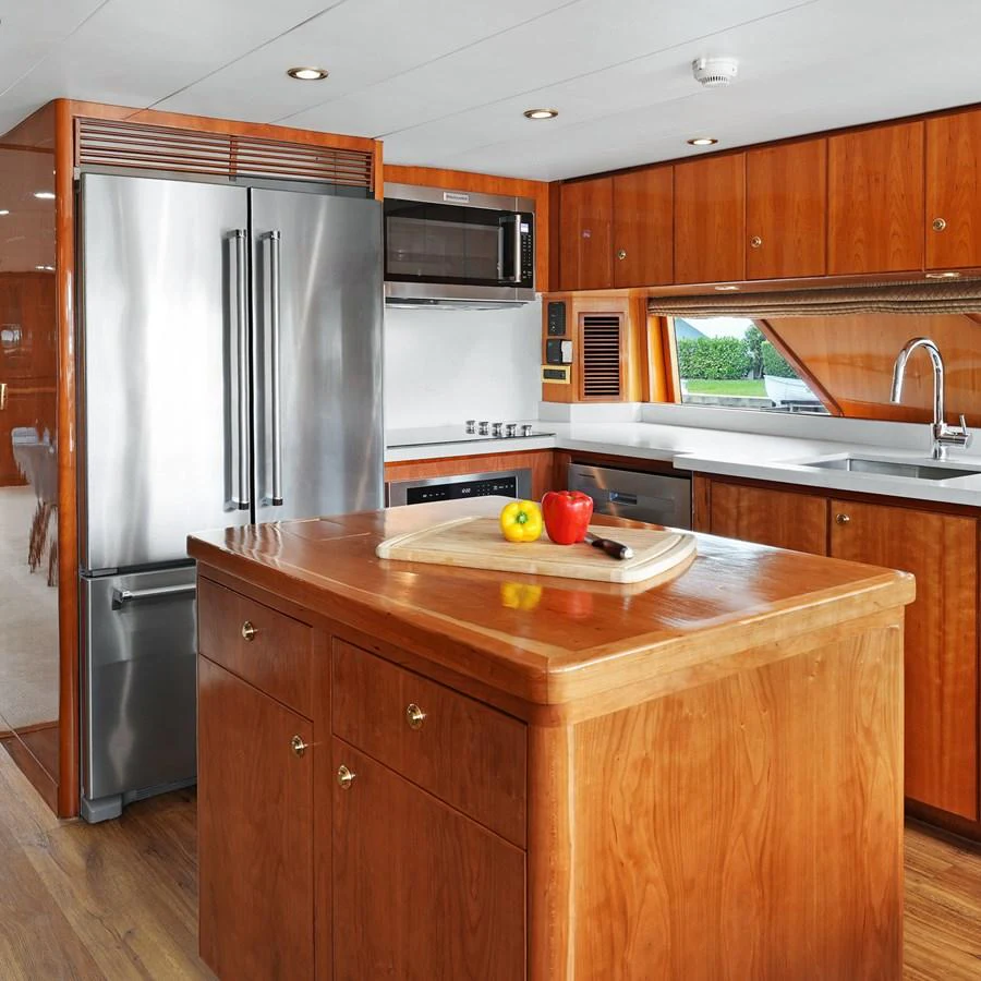 The galley features modern appliances and warm wooden cabinetry, creating a welcoming space for culinary endeavors. aboard MILES AWEIGH Yacht for Sale