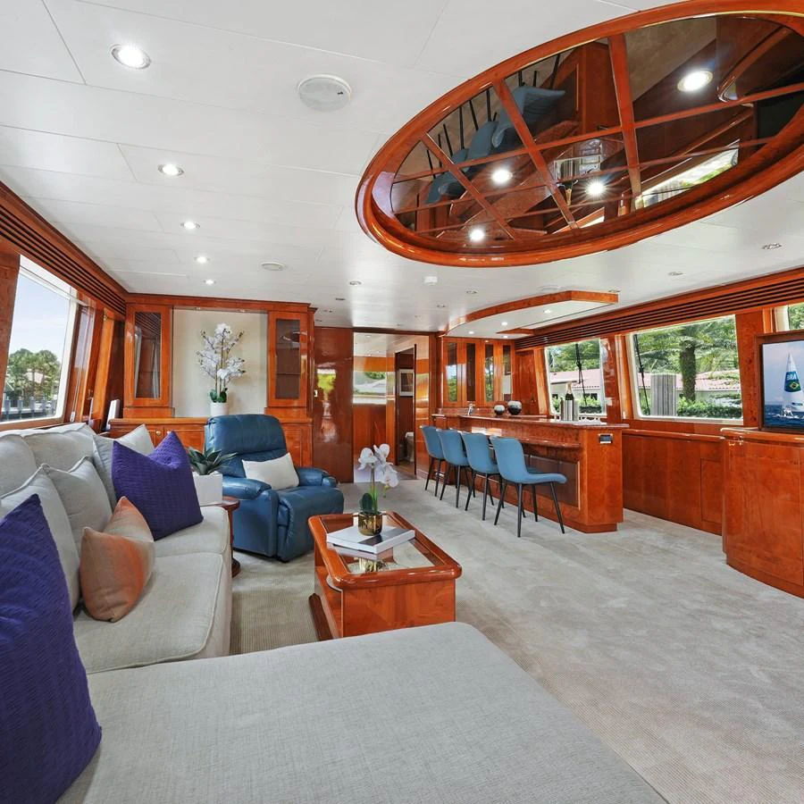 The yacht's salon features luxurious seating, a bar area, and elegant wood finishes. aboard MILES AWEIGH Yacht for Sale