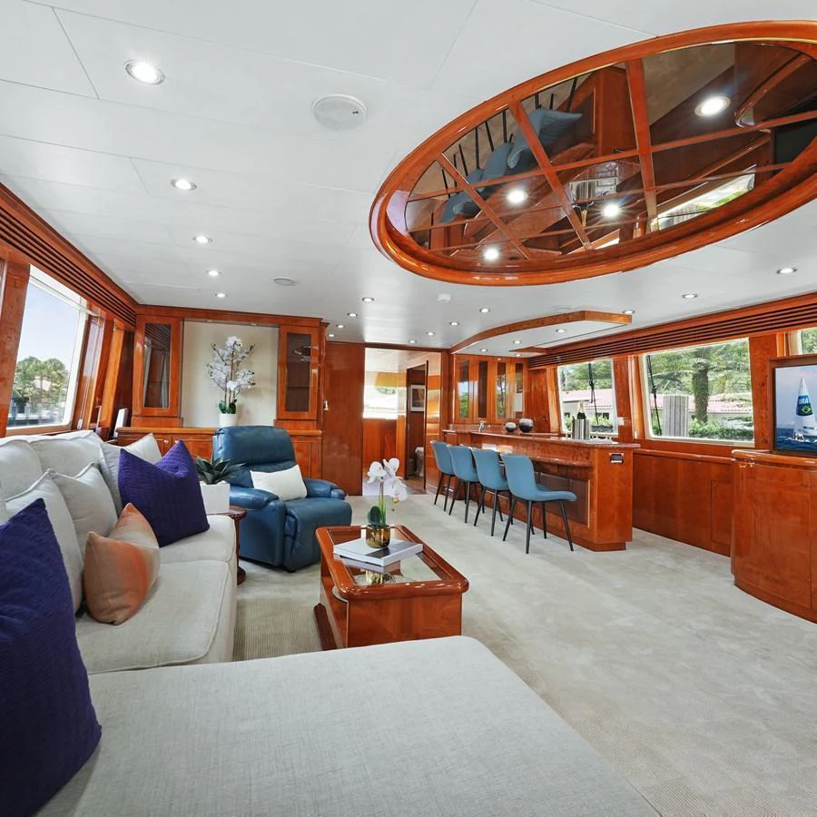 The yacht's salon features luxurious seating, a bar area, and large windows for natural light. aboard MILES AWEIGH Yacht for Sale