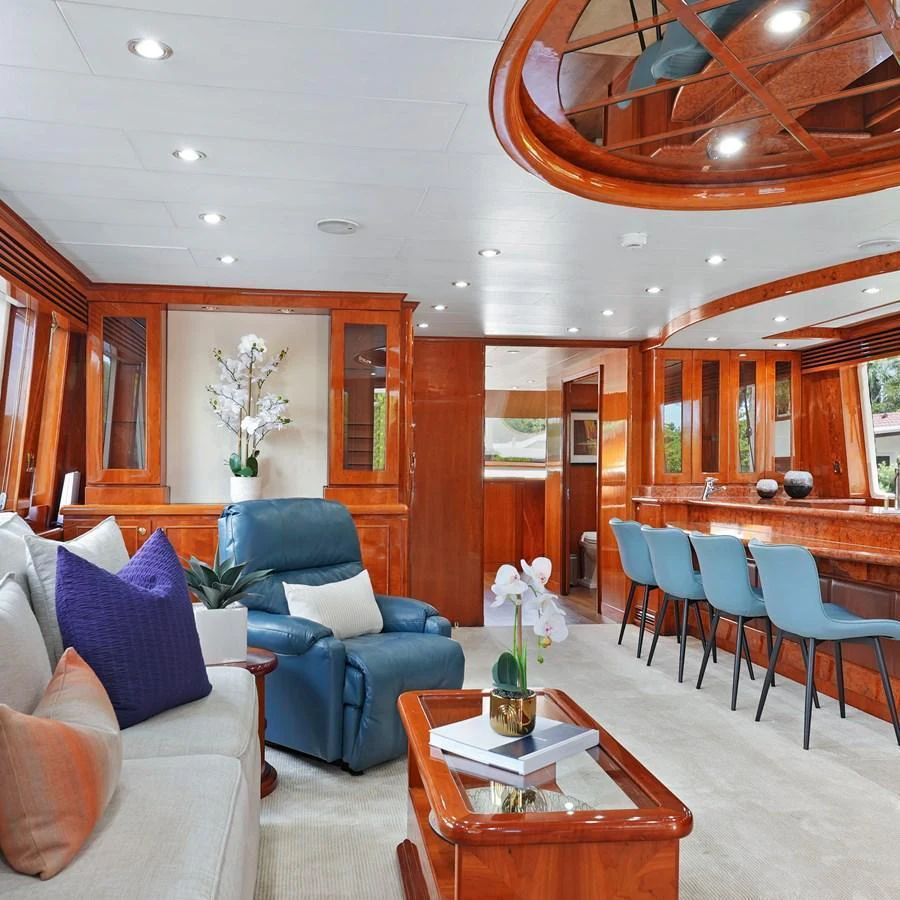 The yacht's salon features luxurious seating, a bar area, and elegant wood finishes. aboard MILES AWEIGH Yacht for Sale