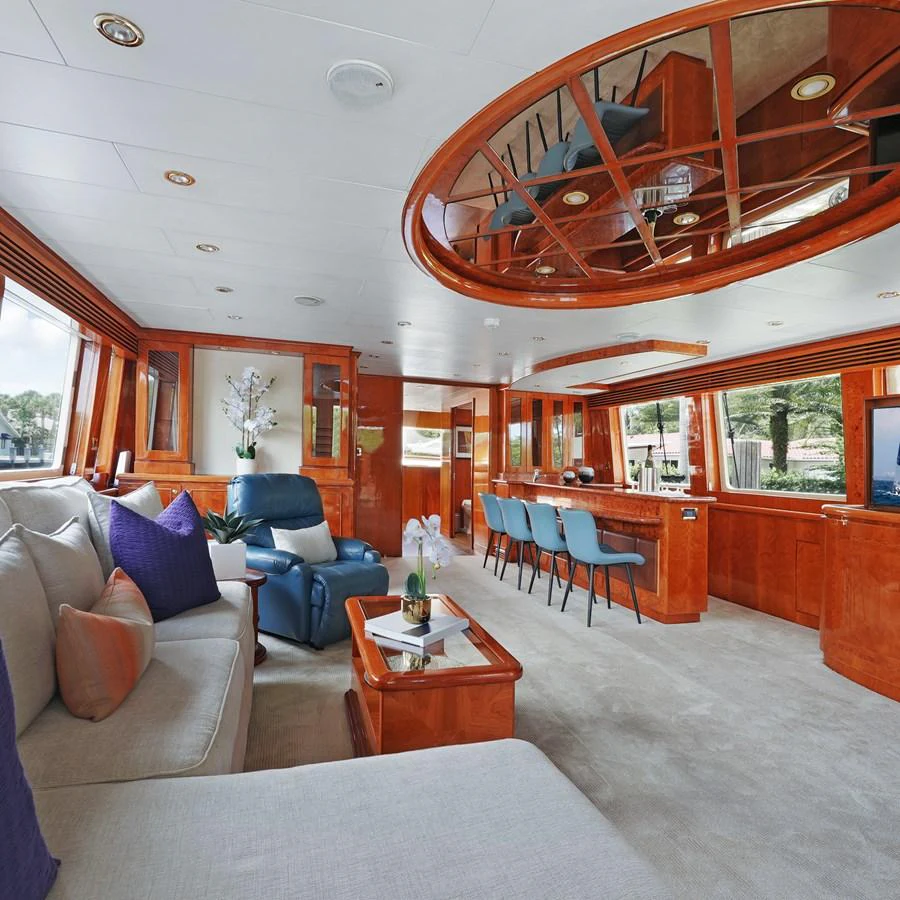 The yacht's salon features luxurious seating, a bar area, and elegant wood finishes. aboard MILES AWEIGH Yacht for Sale