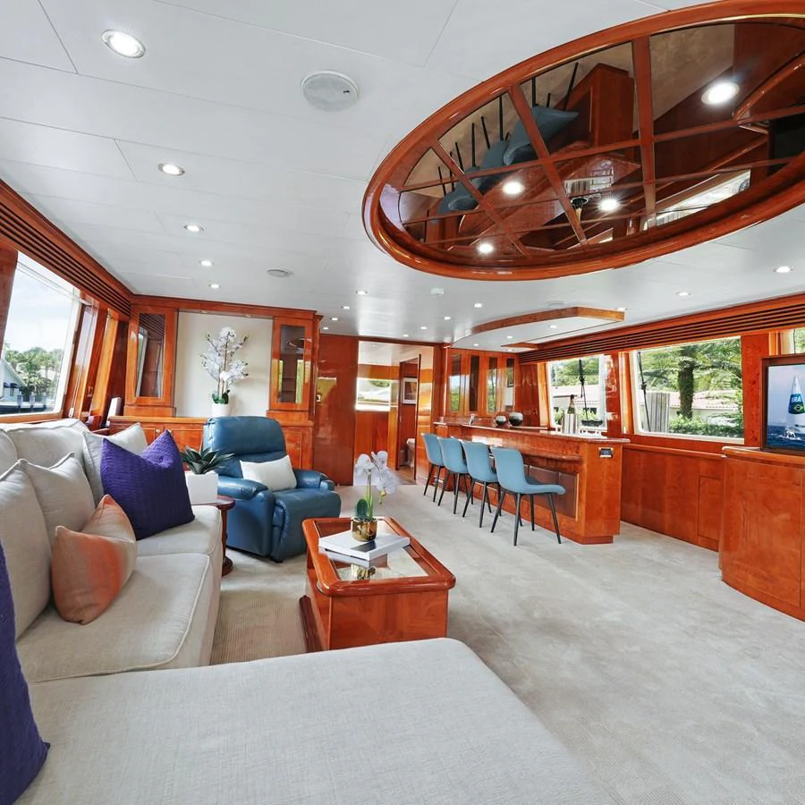 The salon features luxurious seating, a bar area, and elegant wood finishes. aboard MILES AWEIGH Yacht for Sale