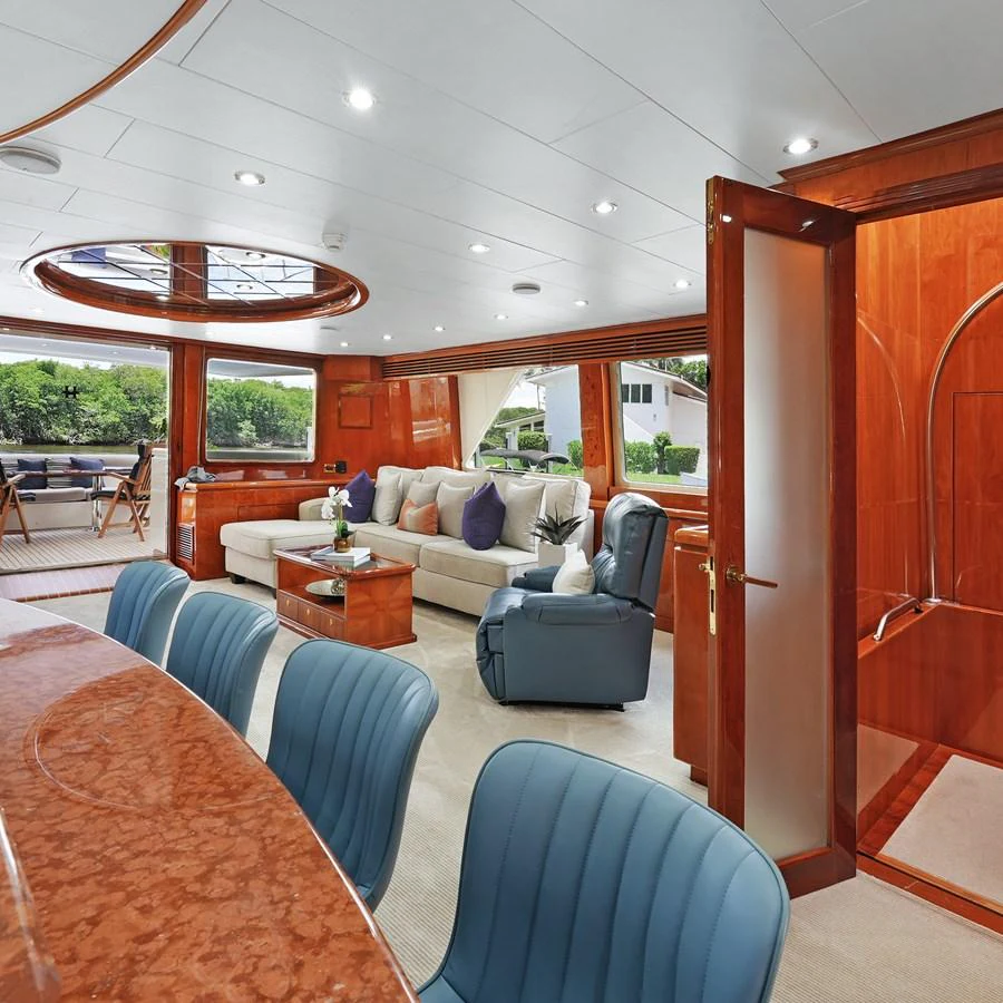 The salon features luxurious seating and elegant wood finishes, offering a comfortable and stylish space for relaxation. aboard MILES AWEIGH Yacht for Sale