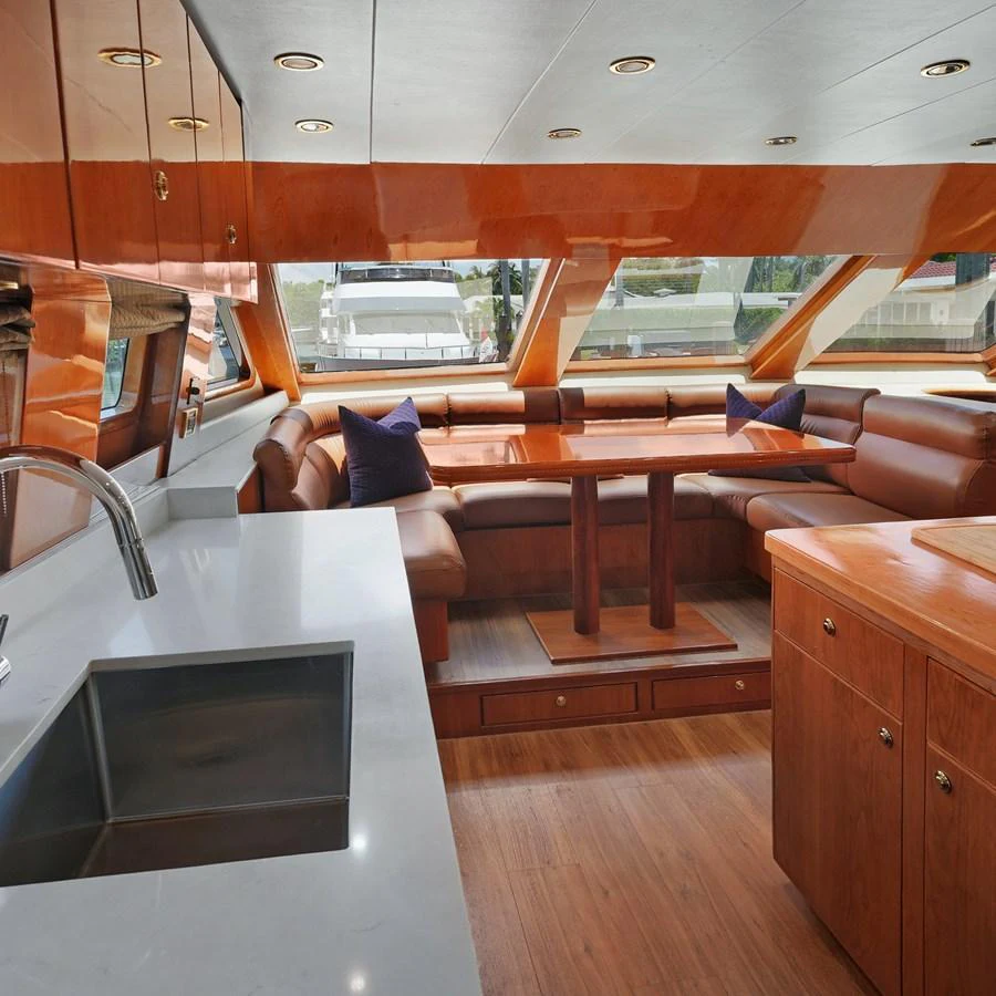 The yacht's galley features a cozy dining area with ample seating and a modern kitchen setup. aboard MILES AWEIGH Yacht for Sale