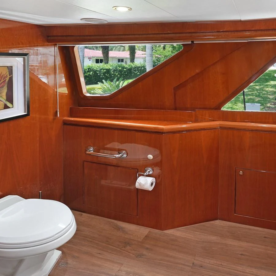 The yacht's bathroom features elegant wooden paneling and modern fixtures. aboard MILES AWEIGH Yacht for Sale