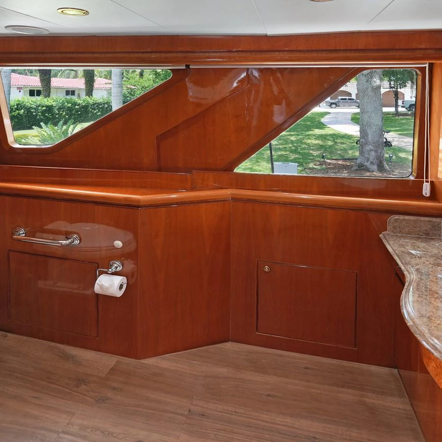 The yacht's interior features rich wooden cabinetry and large windows offering scenic views. aboard MILES AWEIGH Yacht for Sale