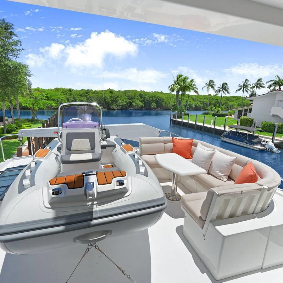 A luxurious yacht tender is showcased on the deck, accompanied by a comfortable seating area with plush cushions. aboard MILES AWEIGH Yacht for Sale