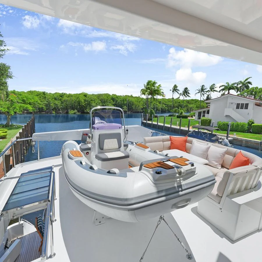The aft deck features a comfortable seating area and a tender, perfect for relaxation and water activities. aboard MILES AWEIGH Yacht for Sale