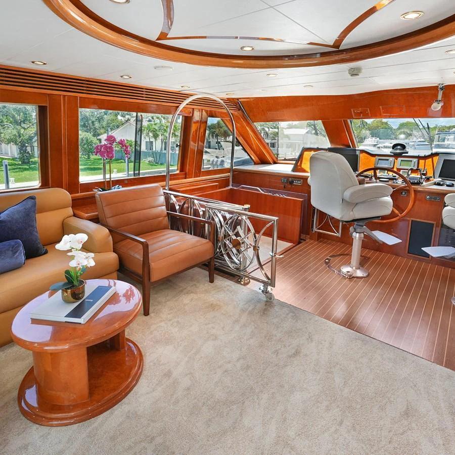 The helm area features luxurious seating and state-of-the-art navigation equipment, complemented by elegant wood finishes. aboard MILES AWEIGH Yacht for Sale
