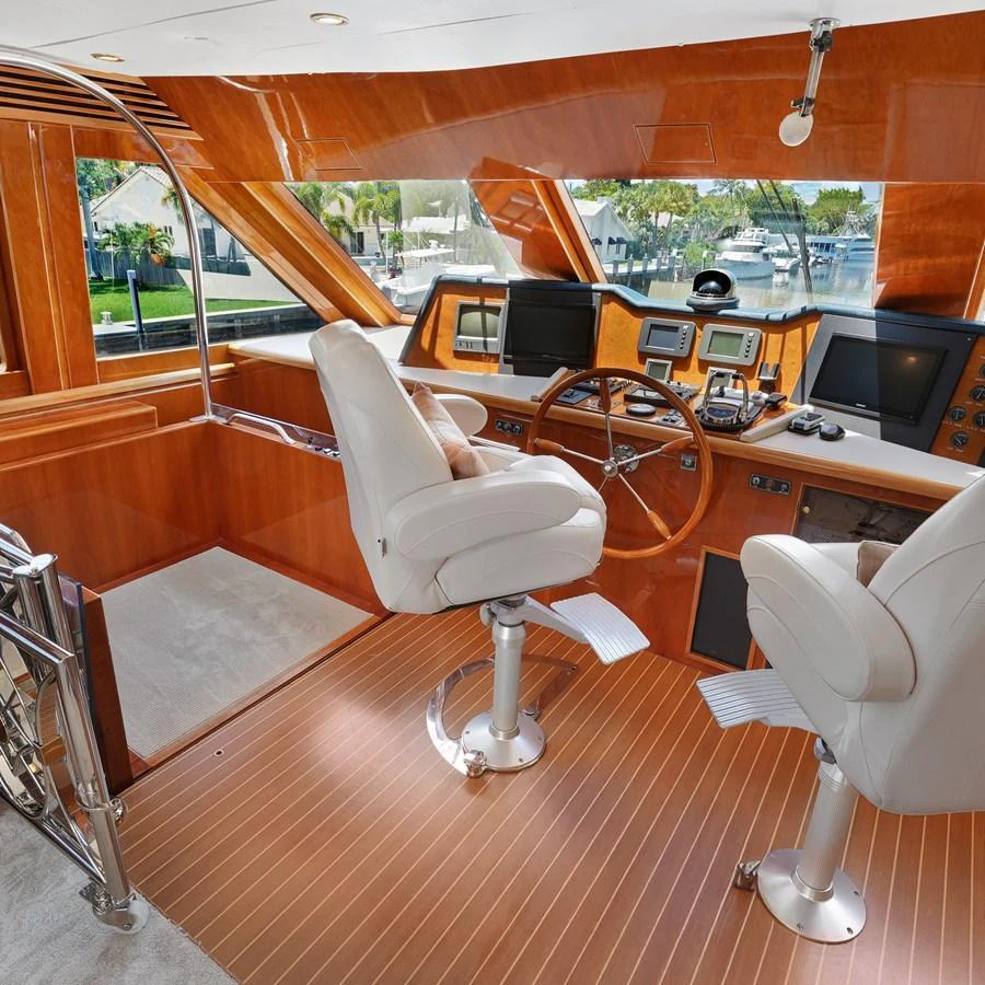 The helm station features luxurious seating and state-of-the-art navigation equipment with a panoramic view. aboard MILES AWEIGH Yacht for Sale