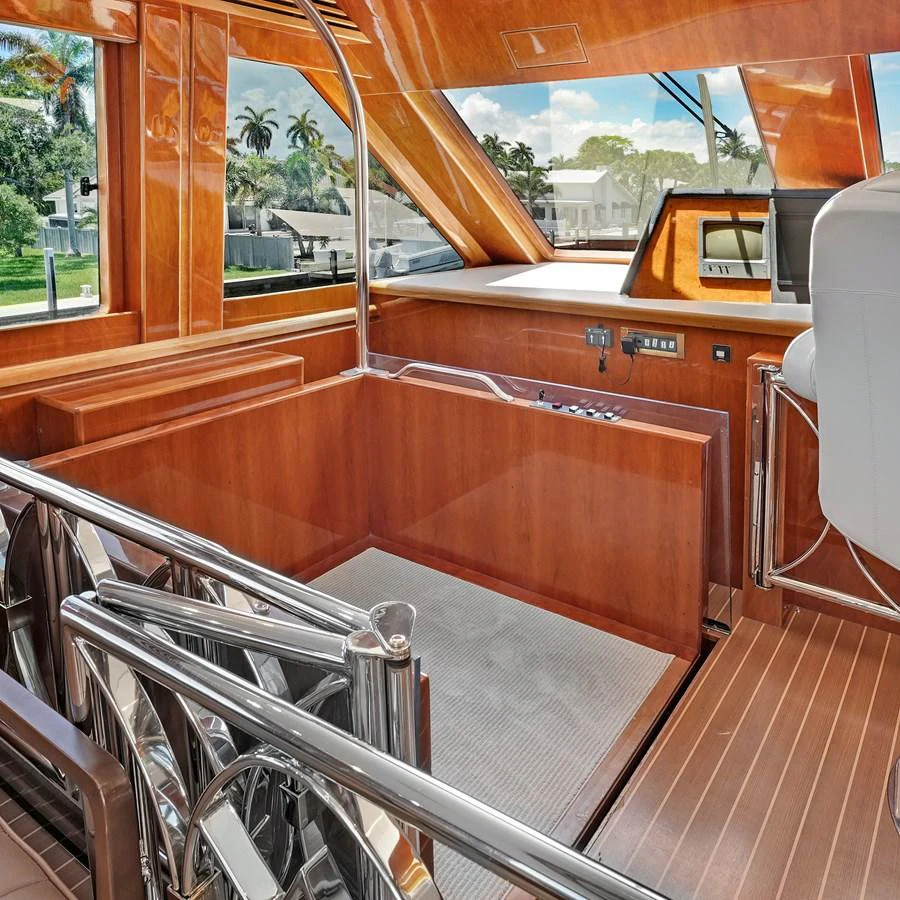 The helm area features luxurious wood finishes and modern controls, offering a sophisticated command center. aboard MILES AWEIGH Yacht for Sale