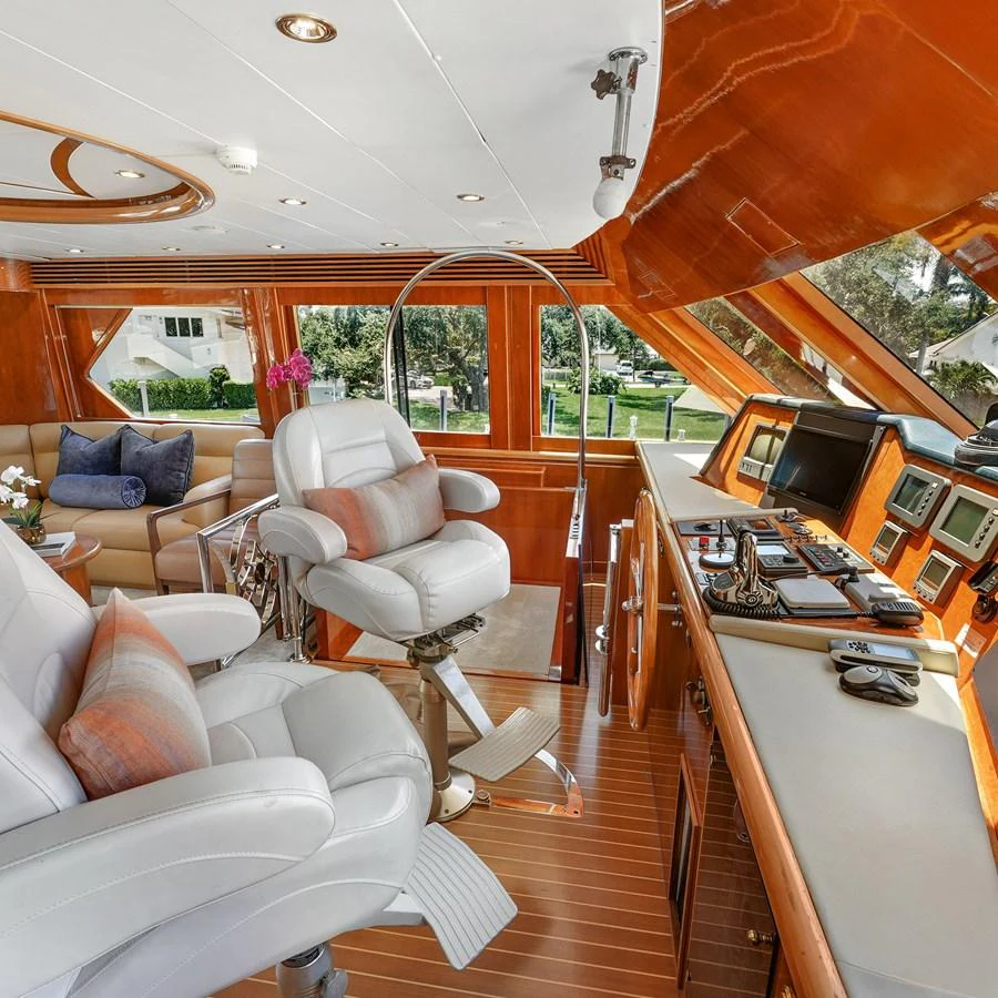 The helm area features luxurious seating and state-of-the-art navigation equipment, surrounded by rich wood finishes. aboard MILES AWEIGH Yacht for Sale