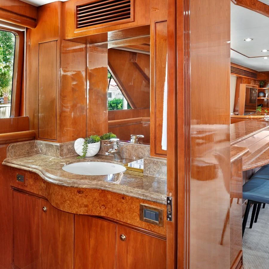 The yacht's bathroom features elegant wood paneling and a marble countertop. aboard MILES AWEIGH Yacht for Sale