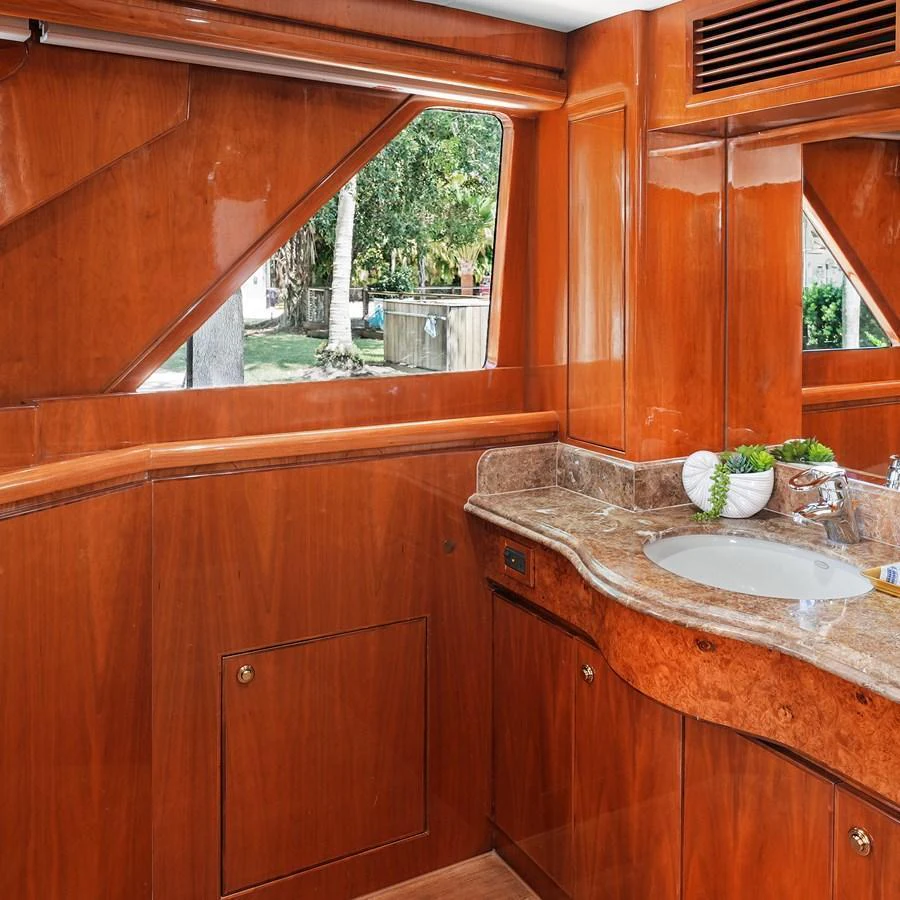 The yacht's interior features a beautifully crafted wooden vanity area with a sink and elegant fixtures. aboard MILES AWEIGH Yacht for Sale
