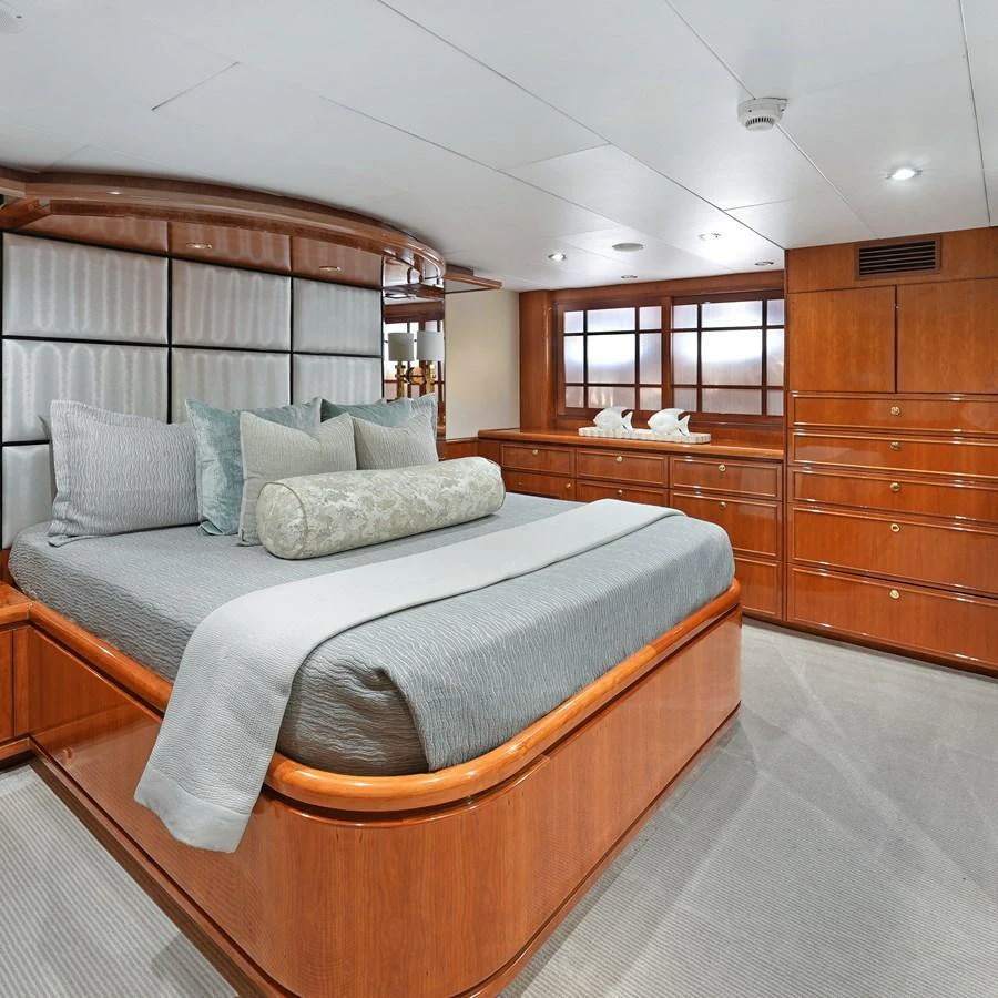 The stateroom features elegant wood paneling and a plush bed with luxurious linens. aboard MILES AWEIGH Yacht for Sale